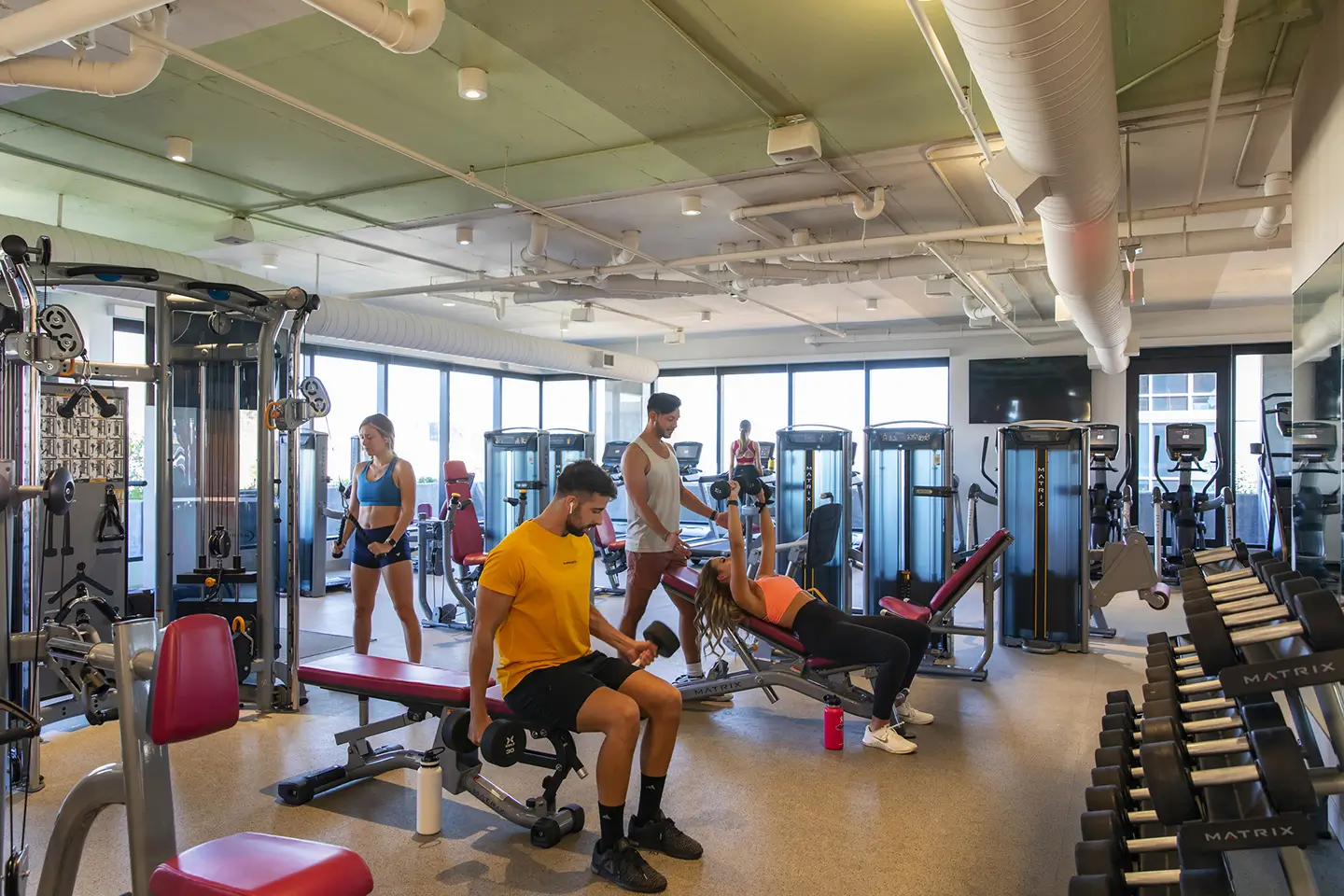 students lighting weights and running on the treadmill at ōLiv Tempe